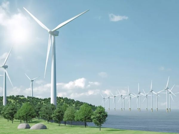 Several wind turbines at the grassland and in the sea.